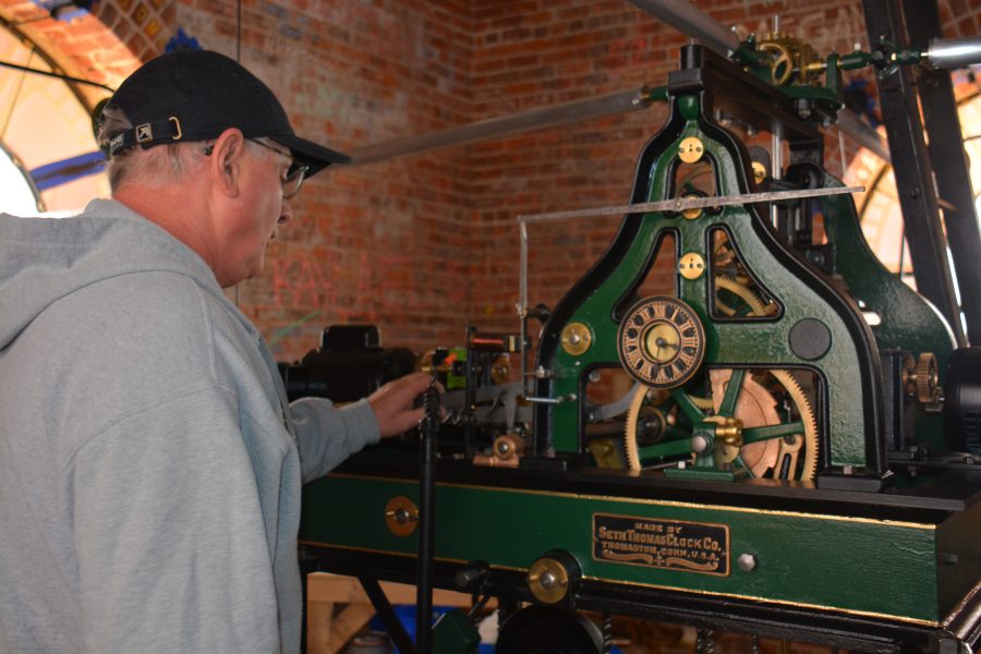 Horologist Phil Wright, a third-generation carpenter, examines the gears which cause bells to chime every hour in Souths historic clock tower.  Wright is a self-taught clockmaker. 