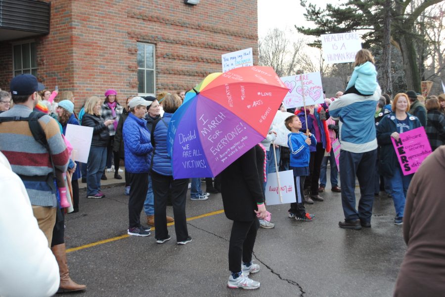 A student holds a rainbow umbrella at the Grosse Pointe Unity March.