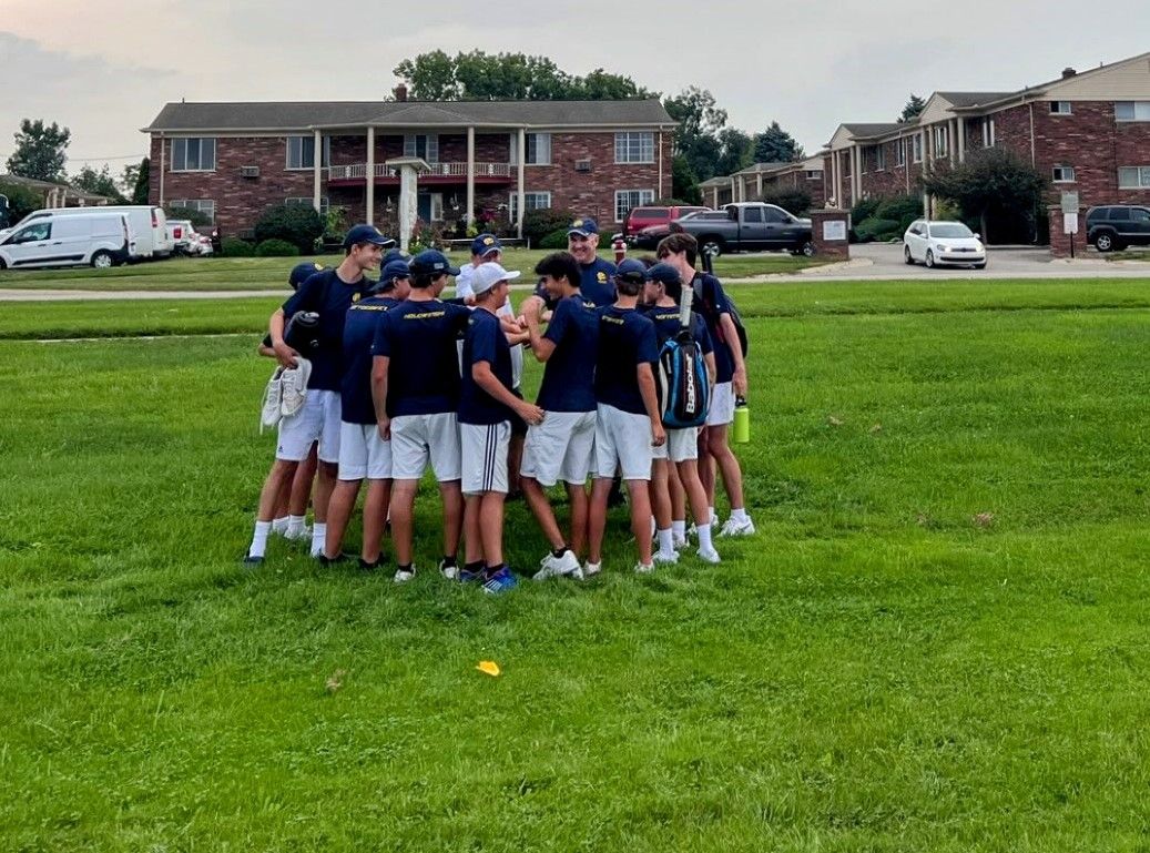 Boys Varsity tennis huddle together after 7-1 victory over Eisenhower.