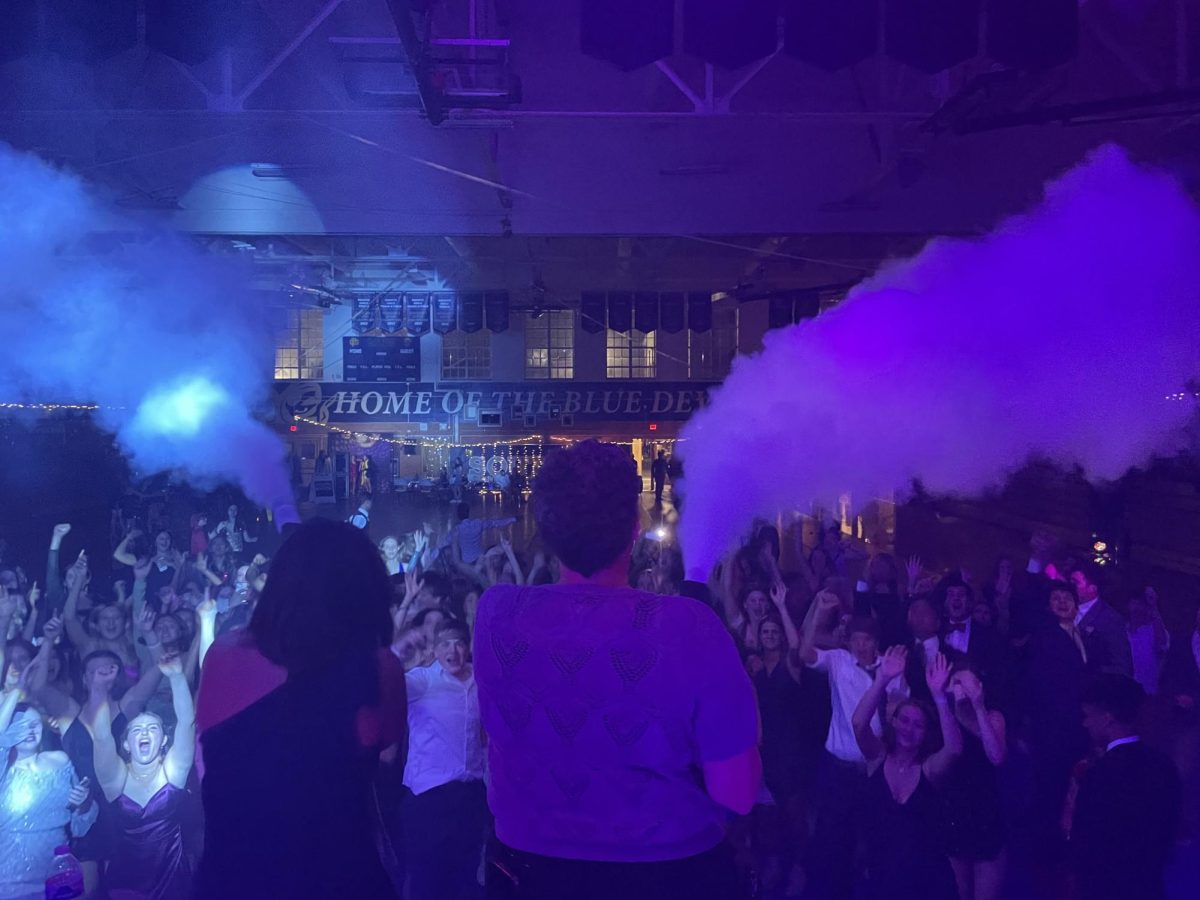 Meg Pierce and Cindy Paravano use smoke guns on the stage of the homecoming dance.