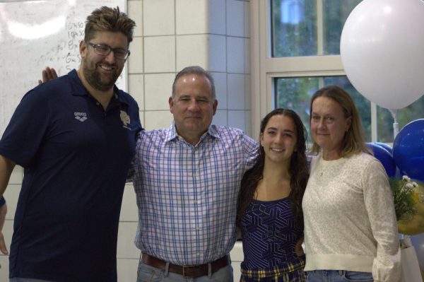 Charlotte Bedsworth 24 poses with her family and swim coach who celebrates  her at Senior night.