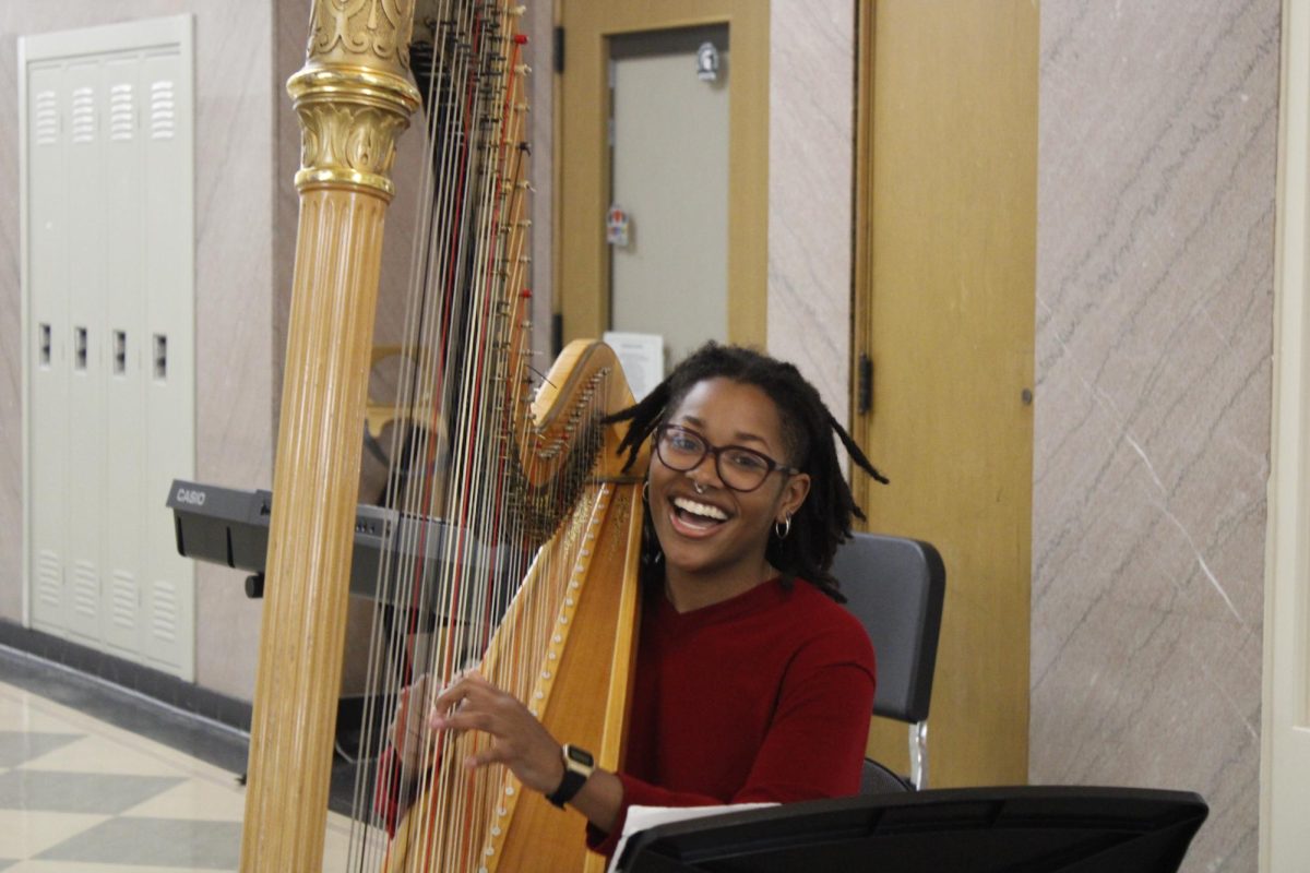 Harpist, Kinzi Allen 24, serenades parents while they roam the halls during the Open House. 