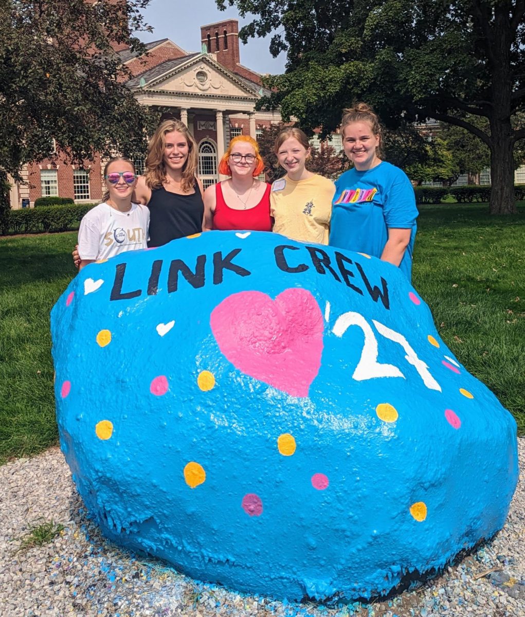 (Left to right) Link Crew leaders Millie Robarge ’24, Jane Maxwell ’24, Kate Ozar ’24, Cecile Walsh ’24 and Ella Taylor ’24 stand behind the rock, which has been decorated to cheer on the Freshman class.