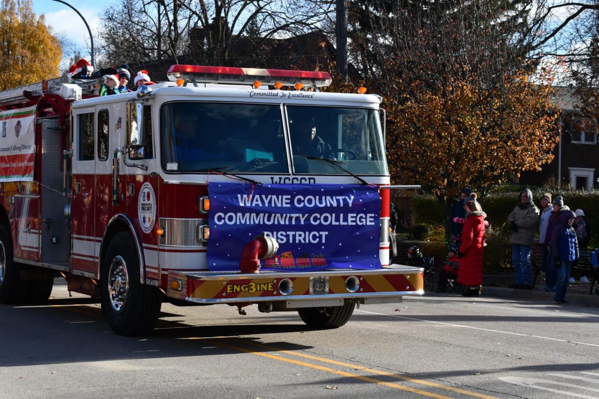 Children wave from the top of a fire truck endorsing Wayne County Community College.

