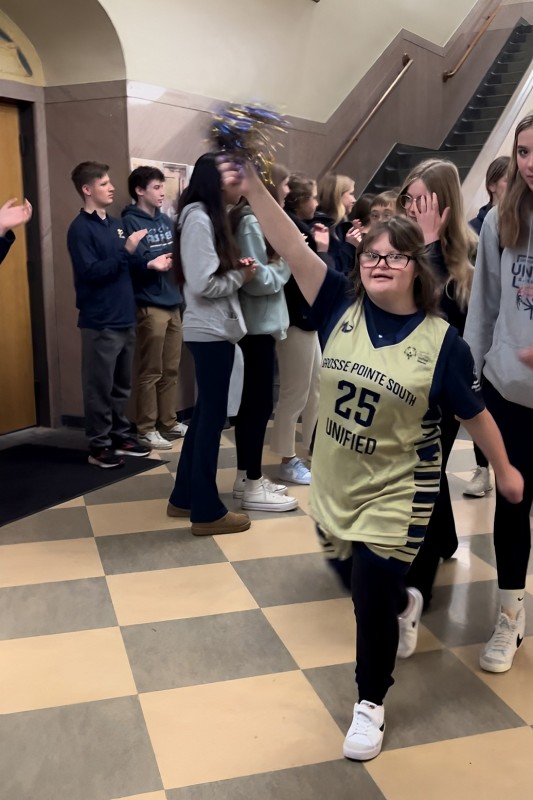 Ava Griesbeck ’24 walking through the halls with a smile on her face while her two sisters are following behind.