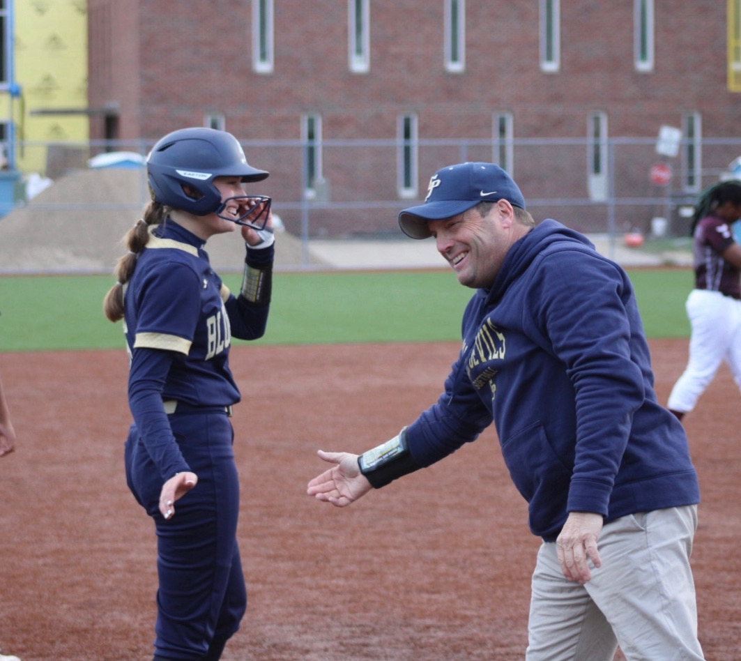  Addie Waller ’24 and her softball coach, Bill Flemming, high-five after a good play made by Waller.