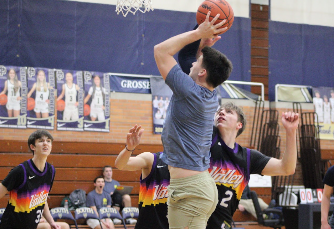 SHOOT YOUR SHOT Junior team member Franklin Gallagher ’25 goes for the layup while surrounded by senior team members.
