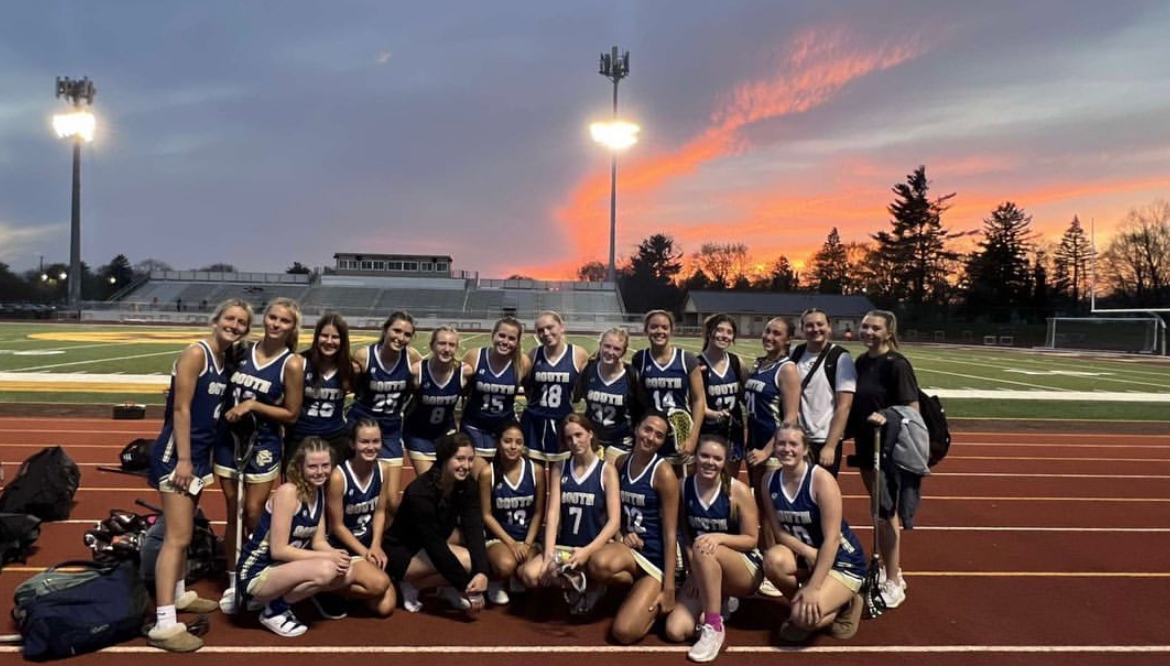 2023+Girls+Varsity+Lacrosse+poses+for+a+picture+after+winning+a+game.