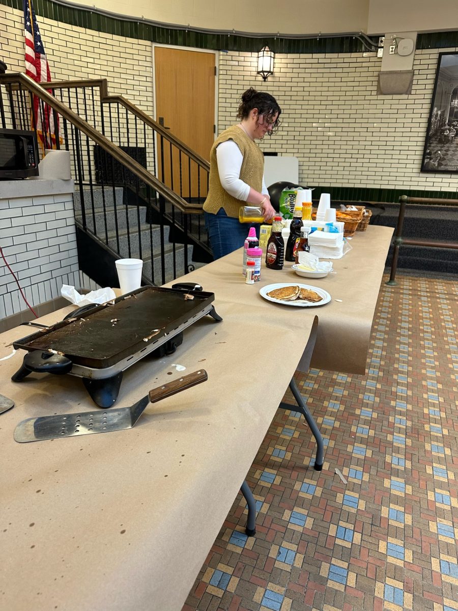  Maggie Houk ’27 pours orange juice and sets up toppings for the pancake breakfast. 