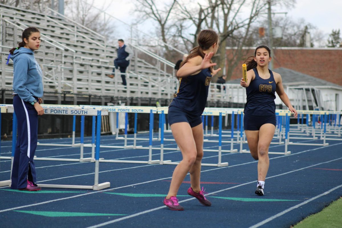 Savannah Spangler sprinting to pass the baton to her teammate.