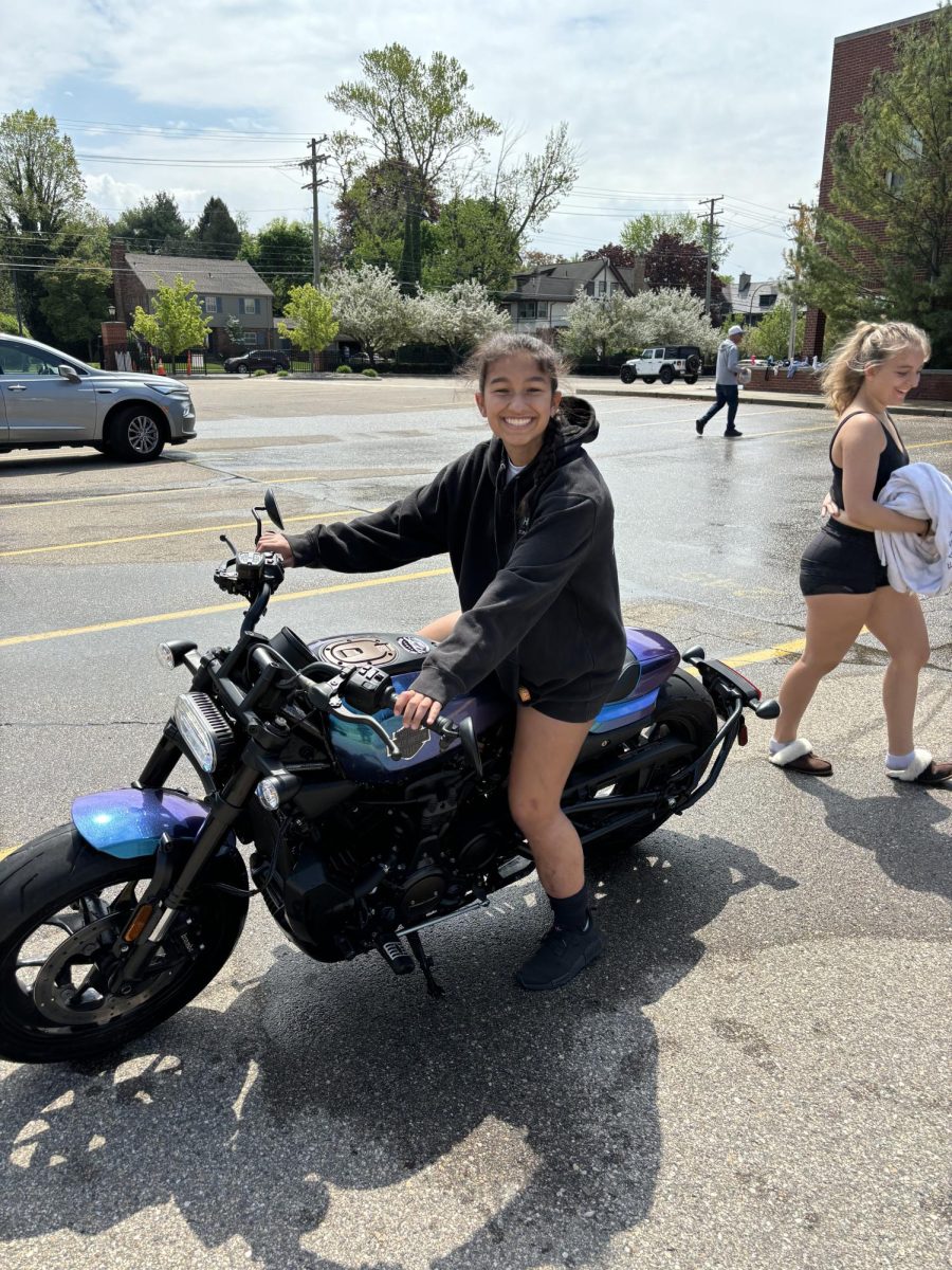  Savannah Spangler ‘25  poses on motorcycle, that she cleaned at the car wash. This guy saw me taking pictures of his motorcycle and asked me if I wanted to get on it, and of course I said yes, Spangler said.