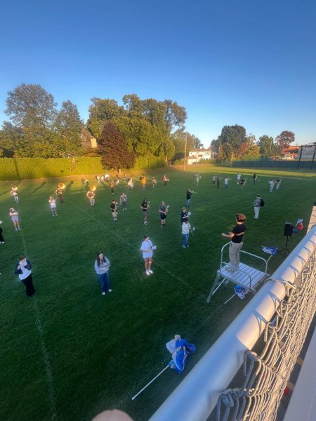 The marching band practices their set behind the bleachers of the football field. These weekly practices help the band perfect their craft in order for them to bring classic football energy to the stadium every game.