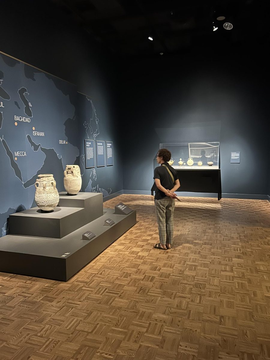 TAKING IT IN A viewer enjoys two handmade water jugs originating in Iraq around 1,000 years ago. These jugs are some of the largest pieces of the collection, but only begin to show the beauty of the exhibit.