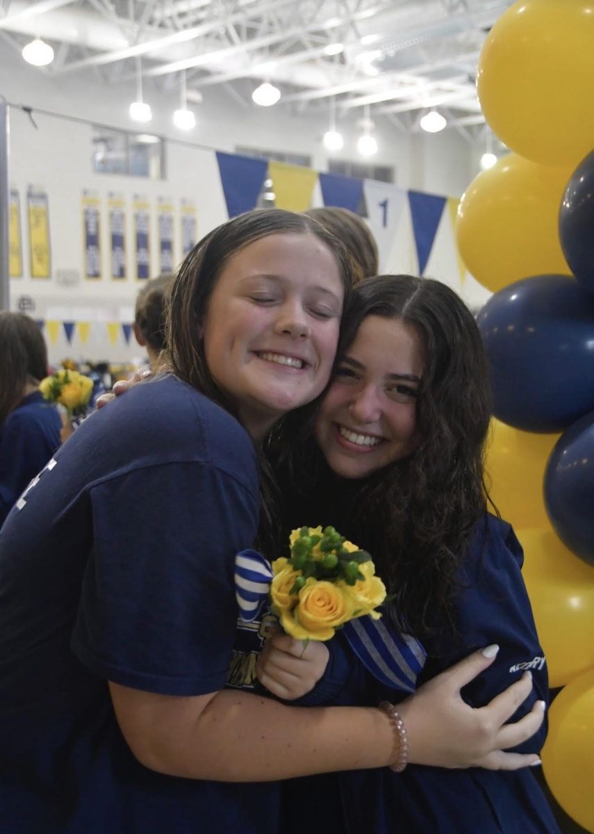 Violet Lincome ‘26 gives Naya Azoury ‘25 a hug on senior night after cheering her on and giving her flowers. (Courtesy of Jessica Bryan)