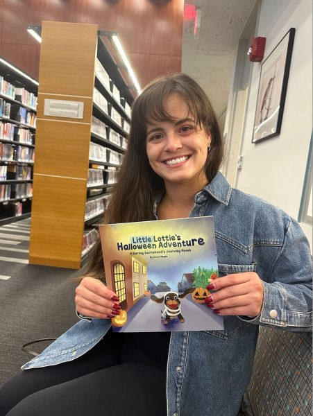 Grace Reyes holds a copy of her freshly completed children’s book, “Little Lottie’s Halloween Adventure.”