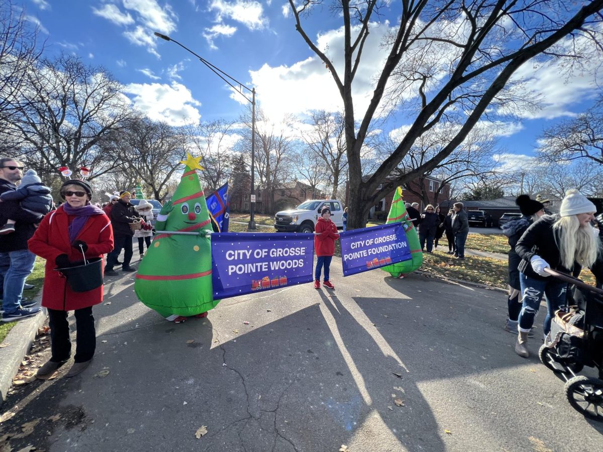 Jolly inflatable Christmas trees, representing the City of Grosse Pointe Woods and the City of Grosse Pointe greet fellow spectators.