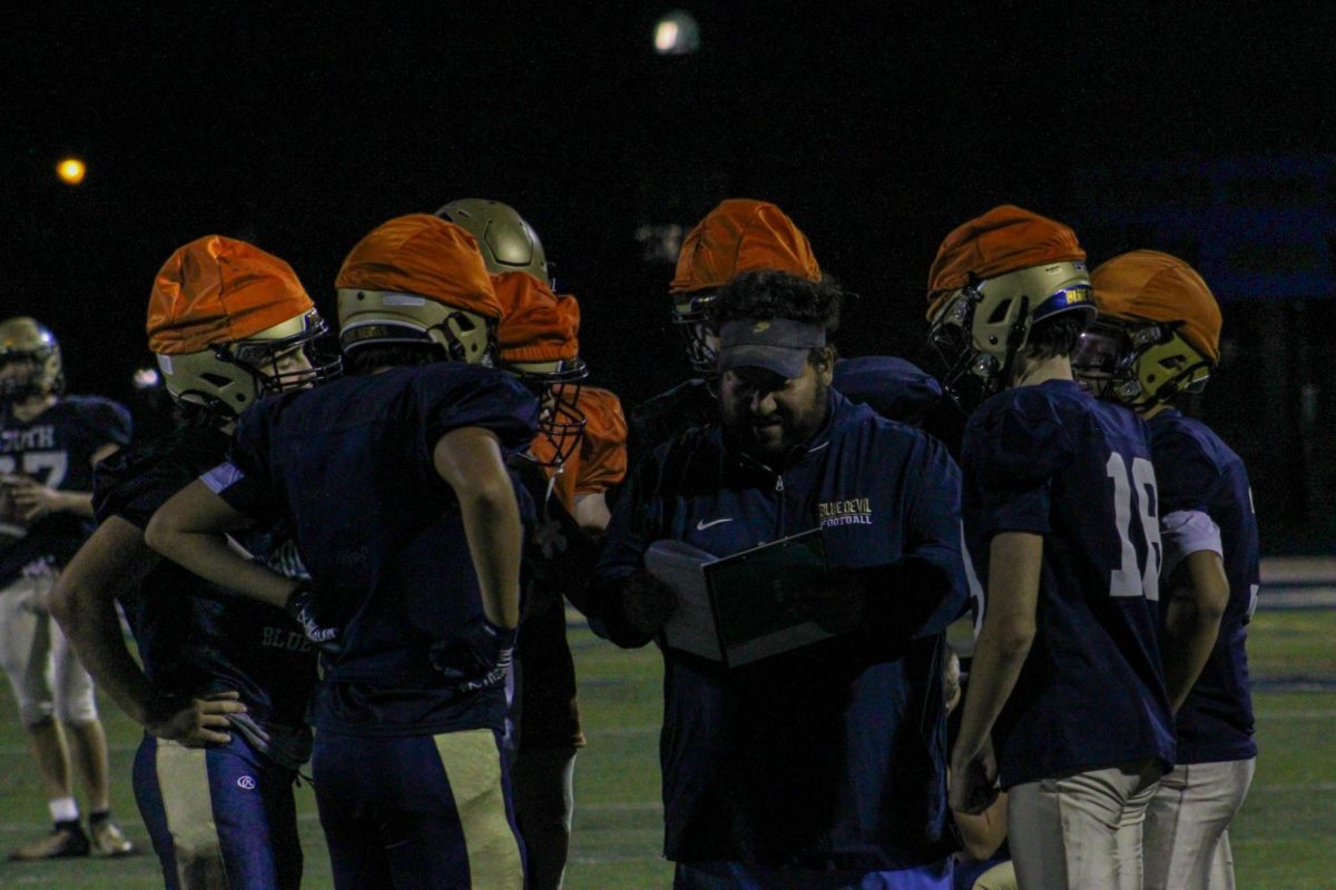 Offensive Coordinator Ray Fillipek works with his receiving core to run a special play. The team has previous scored a season low 27 points last game against Roseville High School.