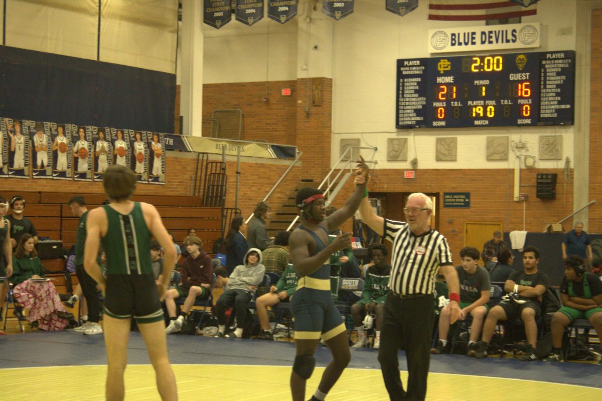 Neil Honablue ’25 gets his hand raised by the referee after winning his match. He would go on to be undefeated during the meet.