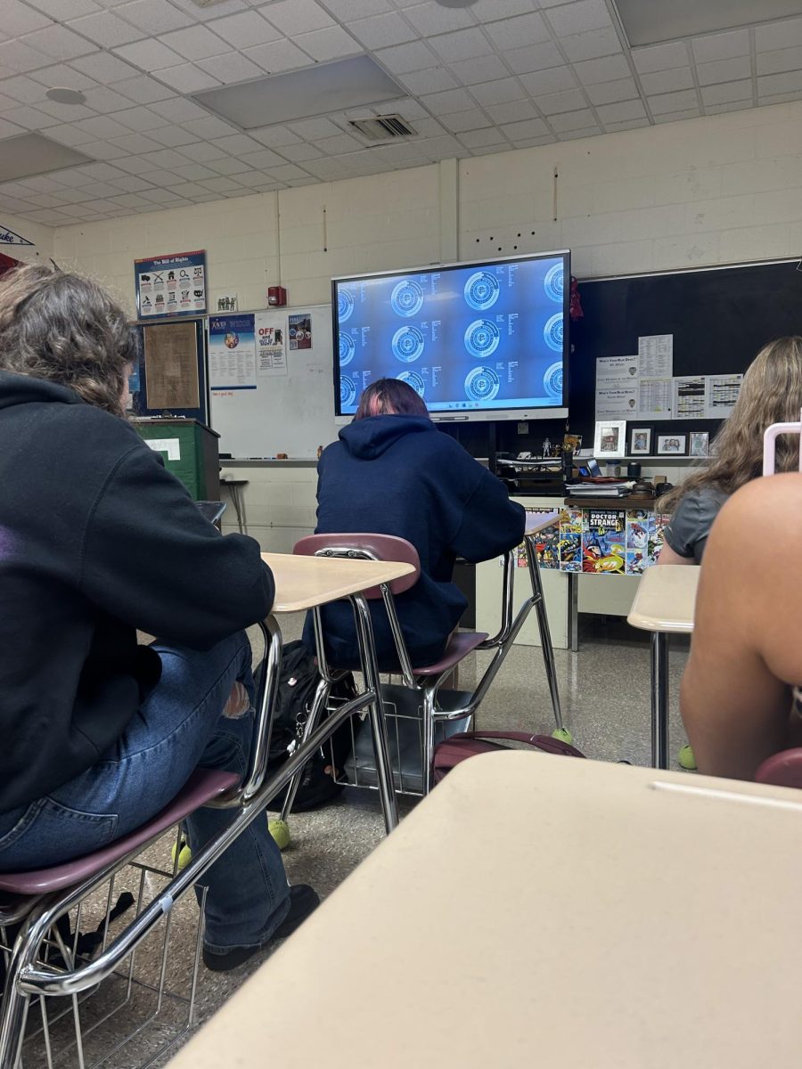 Students sit in their desks during 5th period trying to stay awake, they take annotations and notes on their devices.