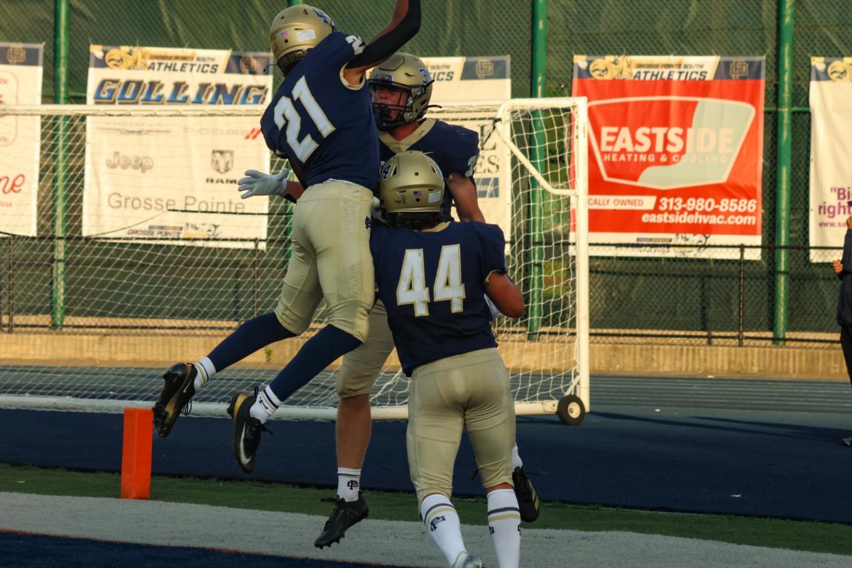 Zach Willson ’26, Throop Linnell and Liam Willson both ’27 celebrate after Willson scores his first varsity touchdown against Detroit Renaissance on Aug. 28.