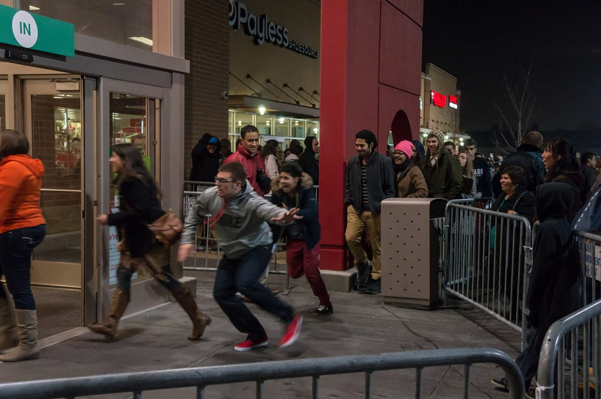 A line of people stretches out as far as the eye can see, the anticipation of the store opening on the early morning of Black Friday is building amongst the crowd. When the doors open, the anxiously waiting customers rush in, ready to make their purchases.