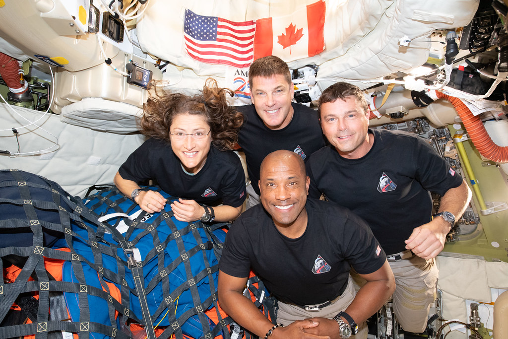 Homeward bound: Astronauts Mission Specialist Christina Koch, Mission Specialist Jeremy Hanson, Commander Reid Wisman, and Pilot Victor Glover pose for a photo inside the Orion spacecraft on their way home after recently traveling past the far side of the moon on April 8, 2026.  Photo courtesy of Flickr.