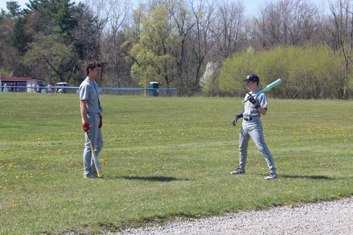TWO DREWS | Juniors Drew Hess and Drew Brown have a friendly conversation during batting practice by the cages before the game. Both players would start in the game, with Hess playing third base and Brown playing Right Field.